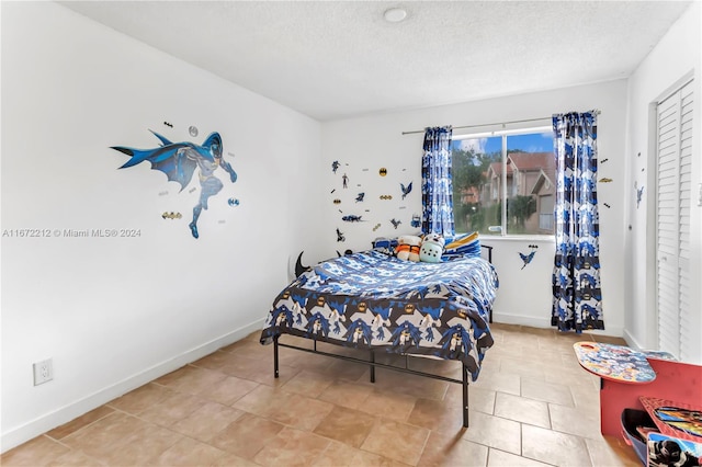 bedroom with light tile patterned flooring and a textured ceiling