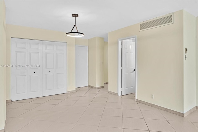 unfurnished bedroom featuring a closet and light tile patterned floors