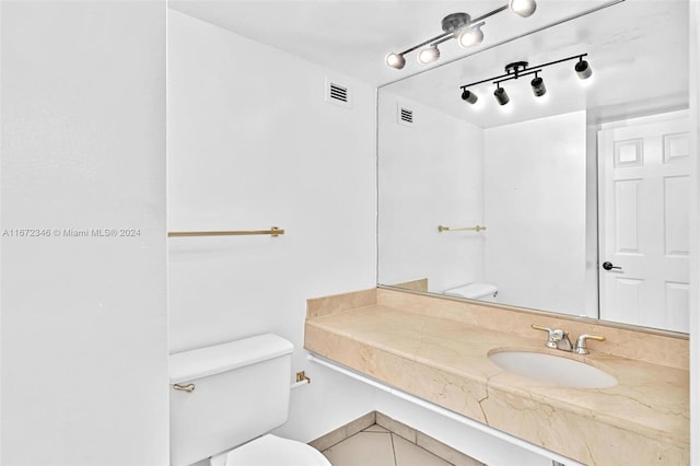 bathroom featuring tile patterned floors, vanity, and toilet