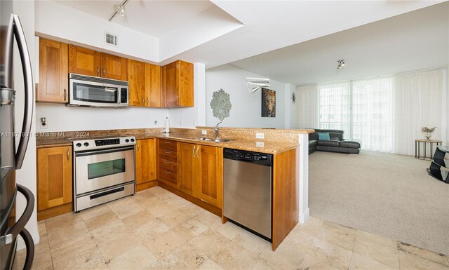 1745 E Hallandale Beach Blvd Unit 1804W, Hallandale Beach, FL 33009 - kitchen featuring a sink, brown cabinetry, stainless steel appliances, a peninsula, and visible vents