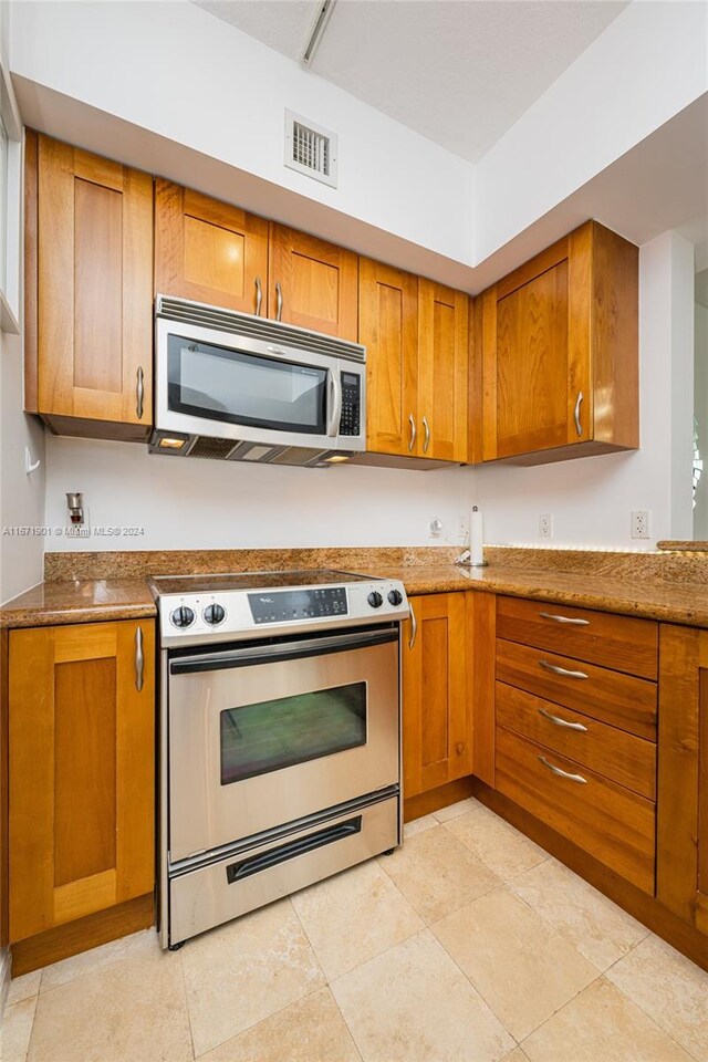 1745 E Hallandale Beach Blvd Unit 1804W, Hallandale Beach, FL 33009 - kitchen featuring visible vents, brown cabinets, and stainless steel appliances