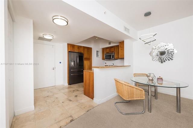 1745 E Hallandale Beach Blvd Unit 1804W, Hallandale Beach, FL 33009 - kitchen with brown cabinets, a peninsula, stainless steel microwave, baseboards, and fridge with ice dispenser