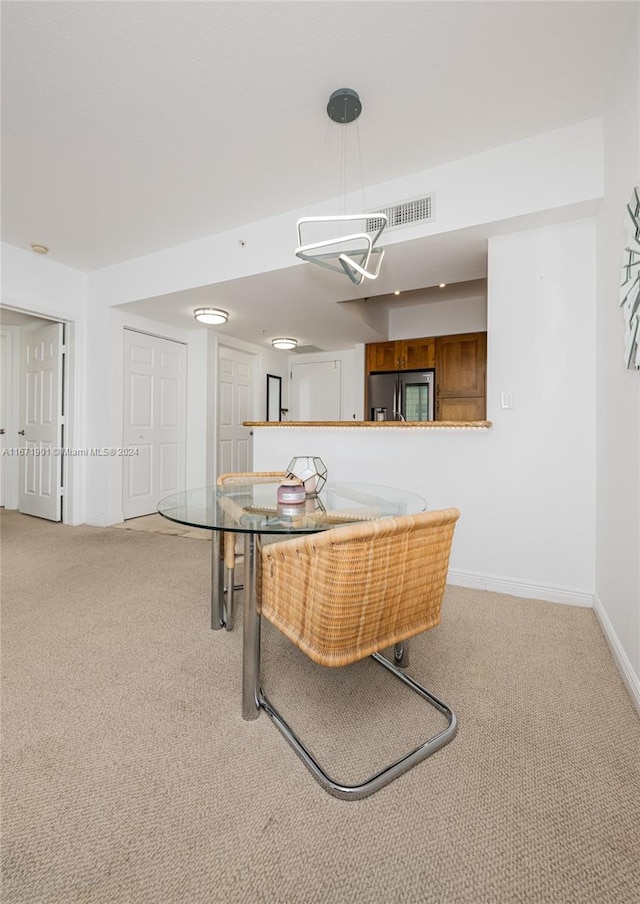 dining space featuring light carpet