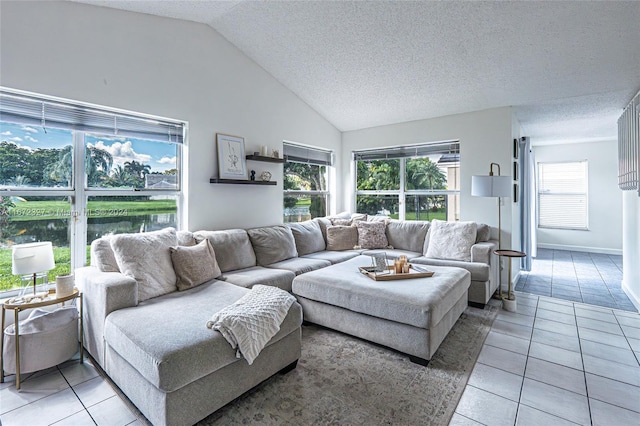 tiled living room featuring a textured ceiling, a water view, plenty of natural light, and lofted ceiling