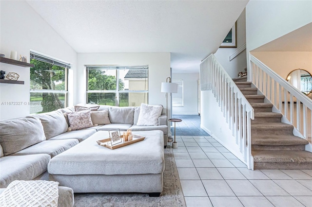 living room featuring light tile patterned floors, a textured ceiling, and vaulted ceiling