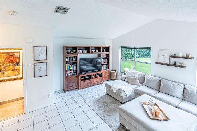 living room featuring a textured ceiling, light tile patterned floors, and vaulted ceiling