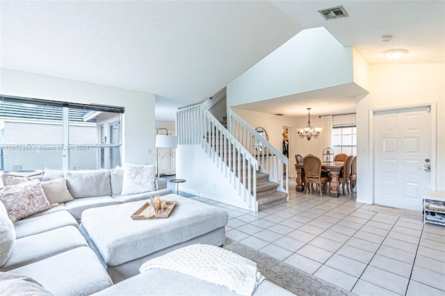 living room featuring light tile patterned floors, a chandelier, and vaulted ceiling