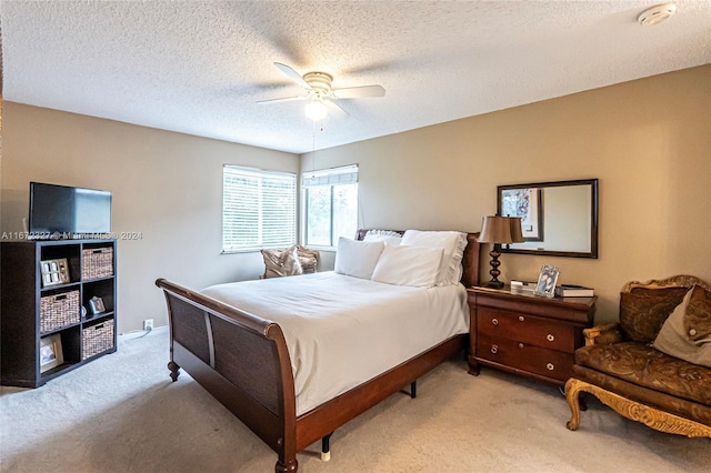 bedroom with light carpet, a textured ceiling, and ceiling fan