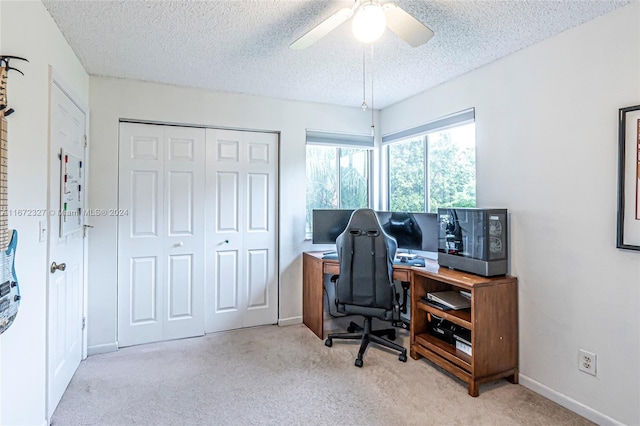 home office with a textured ceiling, light colored carpet, and ceiling fan