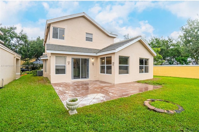 rear view of house featuring central AC, a yard, and a patio