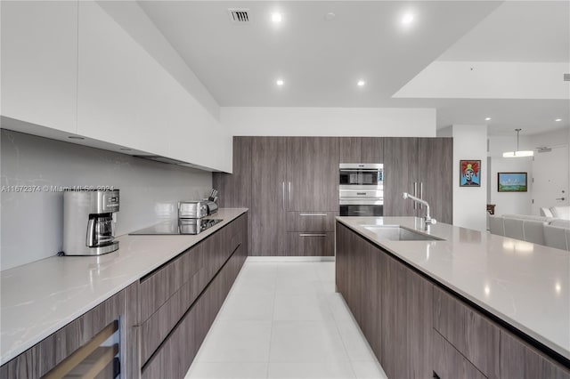 kitchen with white cabinets, light tile patterned flooring, sink, black electric stovetop, and stainless steel double oven