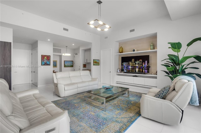 tiled living room with built in shelves and a chandelier