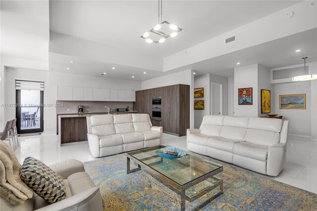 living room with light tile patterned floors and a chandelier