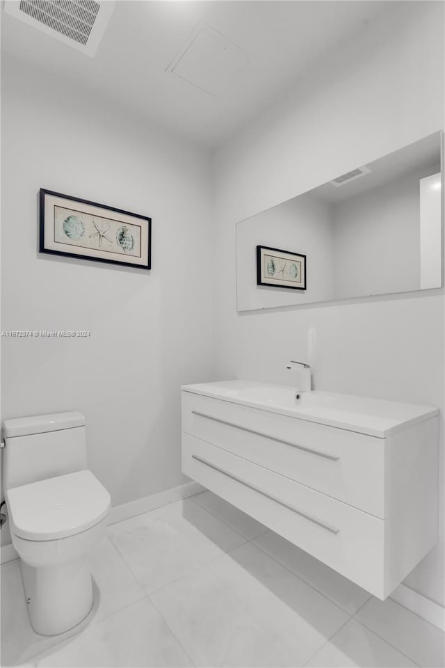 bathroom featuring vanity, tile patterned flooring, and toilet