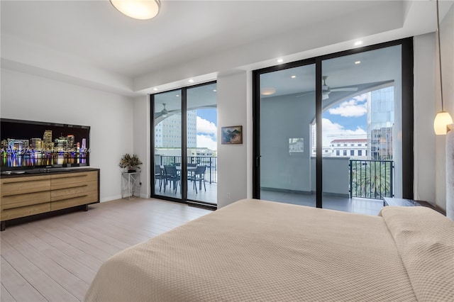 bedroom with multiple windows, hardwood / wood-style floors, and access to exterior