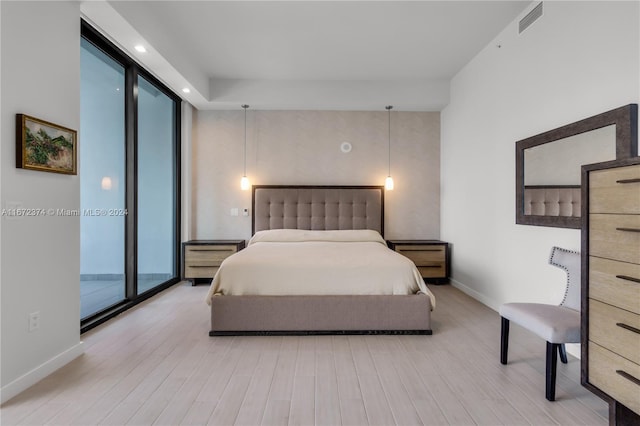 bedroom featuring access to outside, light wood-type flooring, and expansive windows