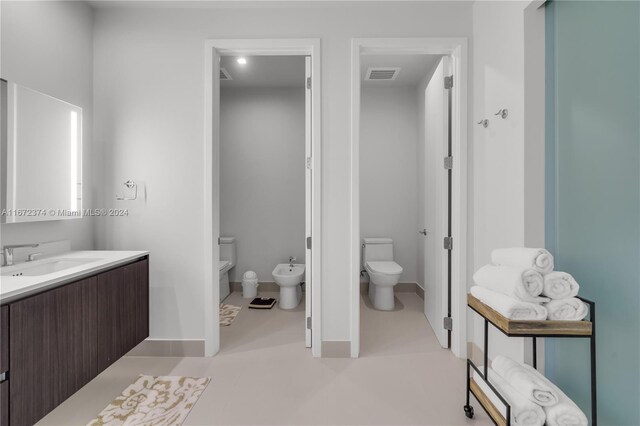 bathroom with a bidet, vanity, and toilet