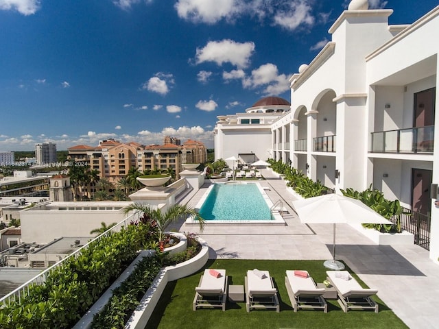 view of pool with a patio area and a yard