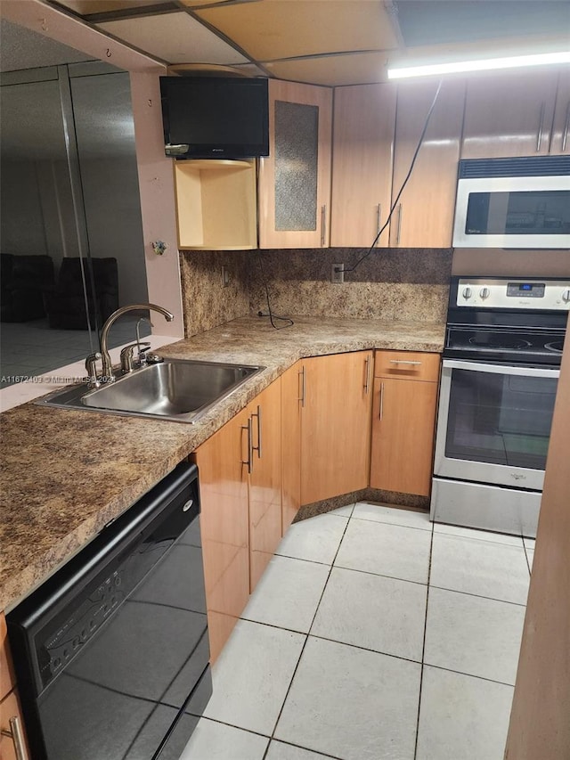 kitchen with decorative backsplash, sink, light tile patterned floors, and stainless steel appliances