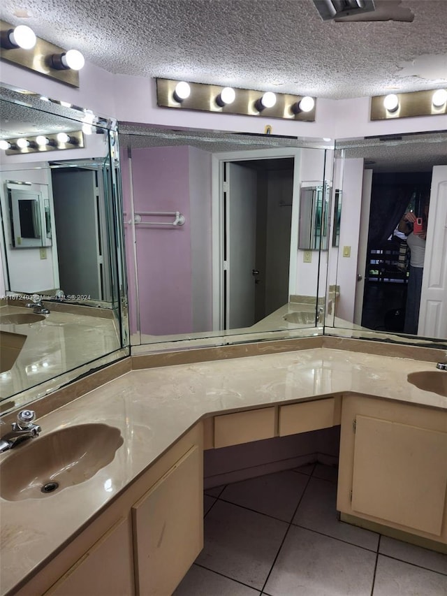 bathroom with a textured ceiling, tile patterned flooring, and vanity