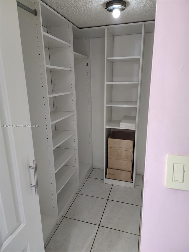 walk in closet with light tile patterned floors and a barn door