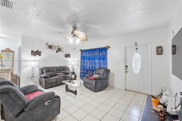 living room with ceiling fan, a textured ceiling, and light tile patterned floors