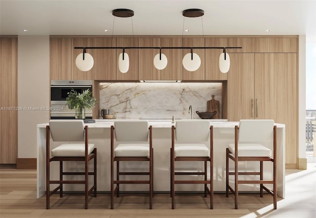 bar with backsplash, light hardwood / wood-style flooring, hanging light fixtures, and oven