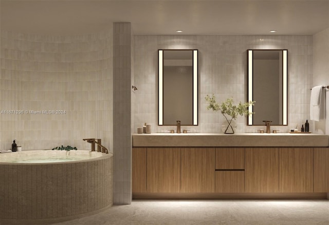 bathroom with vanity, tile walls, and a bathtub