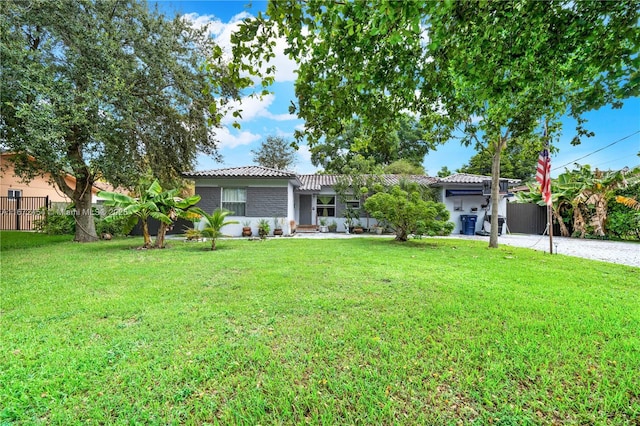 ranch-style house featuring fence, a front lawn, and a tiled roof