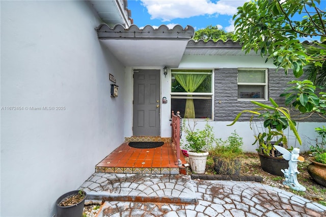 doorway to property featuring stucco siding