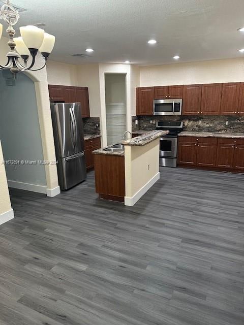 kitchen with stainless steel appliances, dark hardwood / wood-style flooring, tasteful backsplash, and a center island