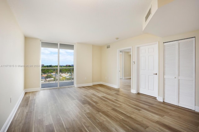 unfurnished bedroom featuring access to outside, light wood-type flooring, and a closet