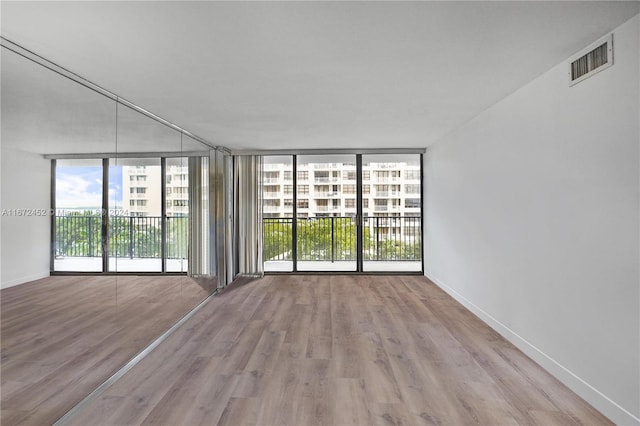 empty room featuring light hardwood / wood-style floors and floor to ceiling windows