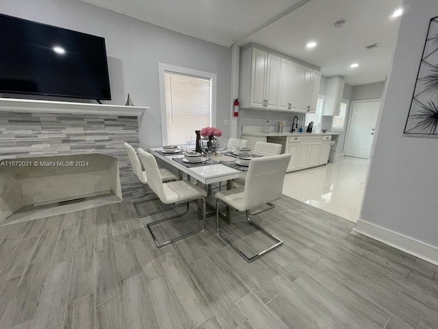 dining space with sink and light hardwood / wood-style floors