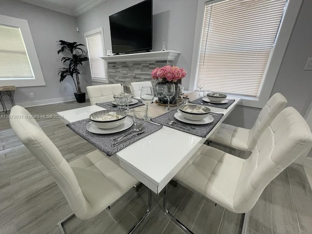 dining room with ornamental molding, wood-type flooring, and plenty of natural light