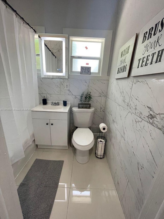 bathroom with a shower with shower curtain, tile patterned floors, vanity, and toilet