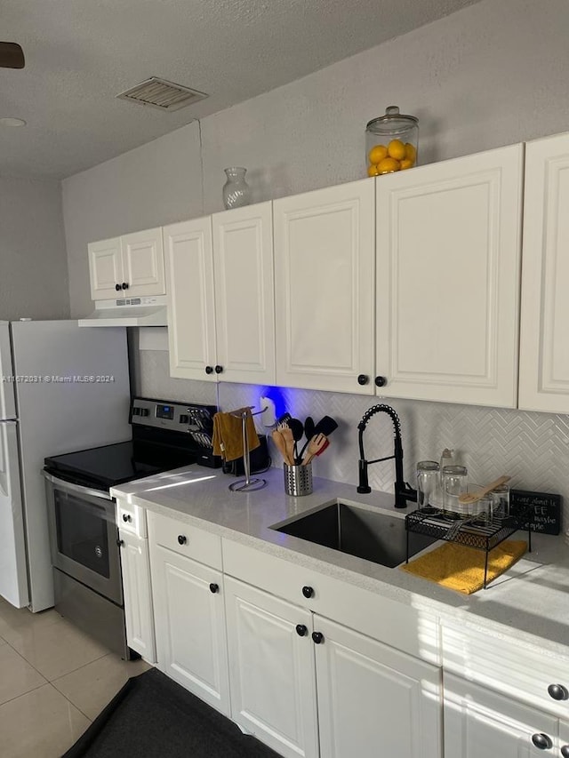 kitchen with white cabinets, sink, light tile patterned floors, tasteful backsplash, and stainless steel electric stove