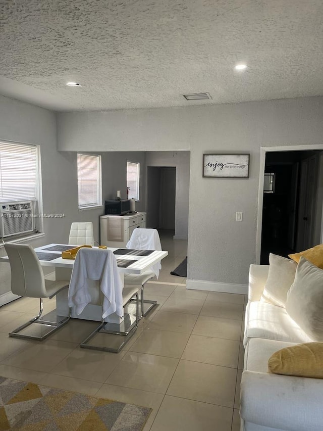 tiled living room with a textured ceiling and cooling unit