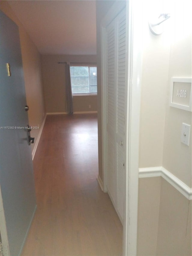 hallway with hardwood / wood-style flooring