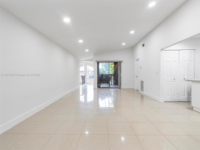 unfurnished living room featuring light tile patterned floors and lofted ceiling