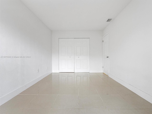 unfurnished bedroom featuring light tile patterned floors and a closet