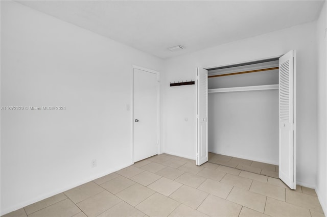 unfurnished bedroom with a closet and light tile patterned flooring