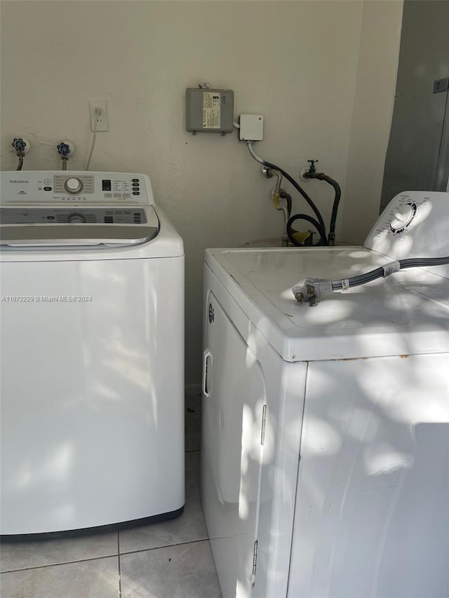 laundry area featuring washing machine and dryer and light tile patterned floors