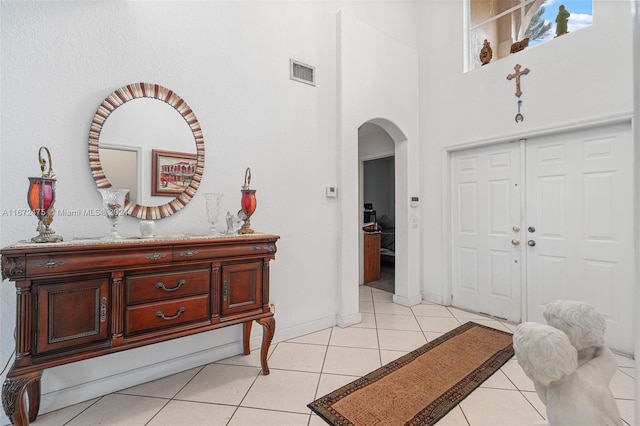 entrance foyer featuring light tile patterned floors and a high ceiling