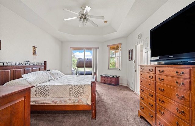 bedroom with light carpet, ceiling fan, a raised ceiling, and access to exterior