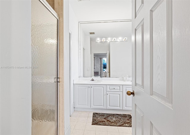 bathroom featuring tile patterned flooring, walk in shower, and vanity