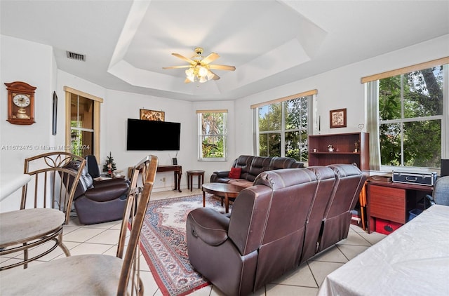 tiled living room featuring a tray ceiling and ceiling fan