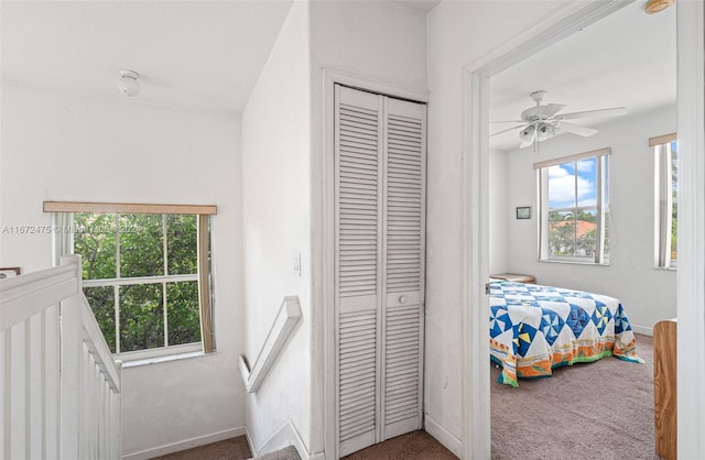 carpeted bedroom with ceiling fan and a closet