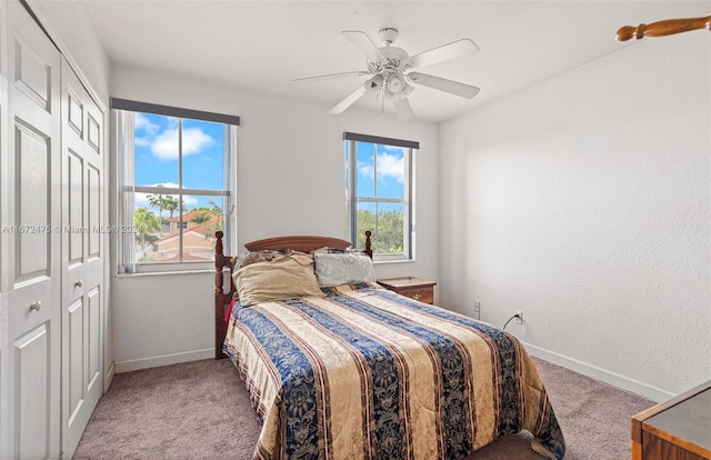 carpeted bedroom with ceiling fan and a closet