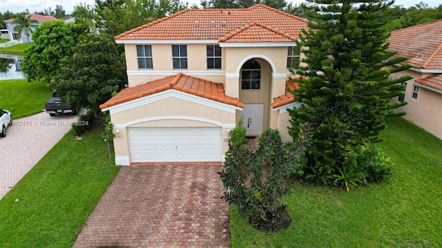 mediterranean / spanish-style house featuring a front yard and a garage